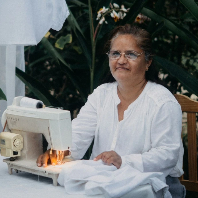A woman sitting at a table with a sewing machine